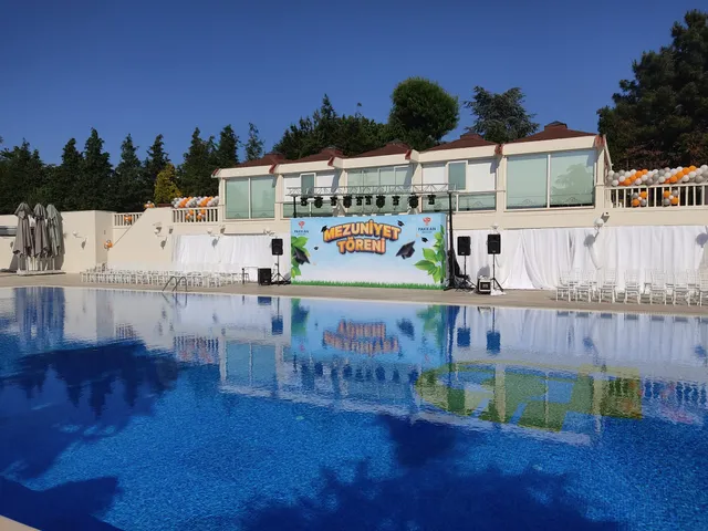 Pakkan Okulları mezuniyet sahnesi — Havuz başındaki mezuniyet töreni için hazırlanan sahne arkası baskının genel görünümü.