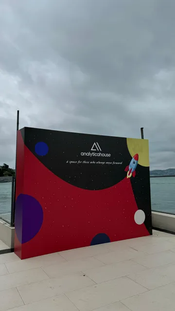 Analyticahouse etkinlik fonu — Deniz kenarındaki etkinlik alanında kullanılan renkli marka fonu.
