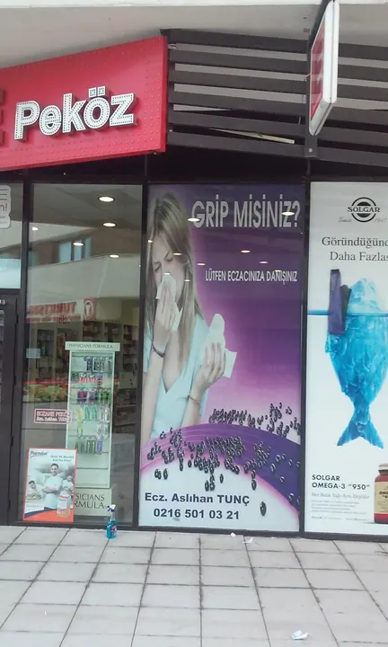 Peköz Eczanesi vitrin baskısı — Dar vitrin alanına uygulanan dikey kampanya görseli.