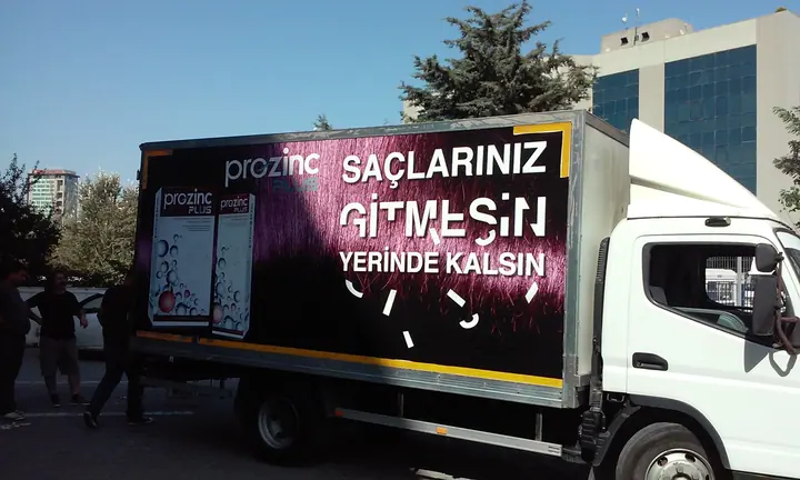 Prozinc araç kaplama — kamyonet — Kutu kasalı aracın yan yüzeyindeki reklam baskısı.