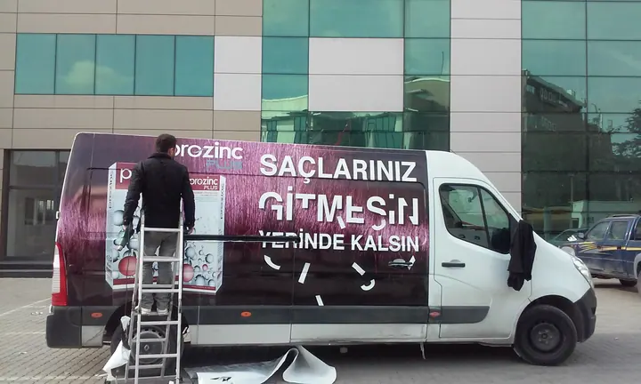 Prozinc panelvan kaplama — Panelvan yan yüzeyindeki reklam baskısının uygulama aşaması.